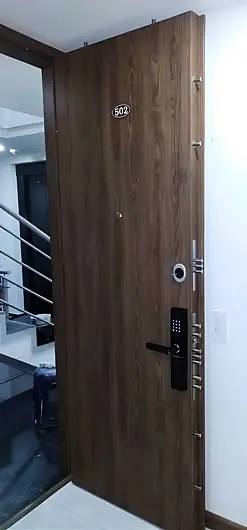 Puerta blindada abierta mostrando cerradura digital